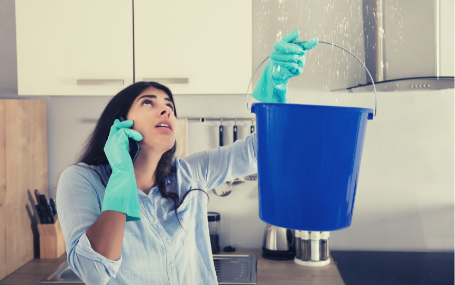 Photo of a woman with an emergency water leak in her kitchen